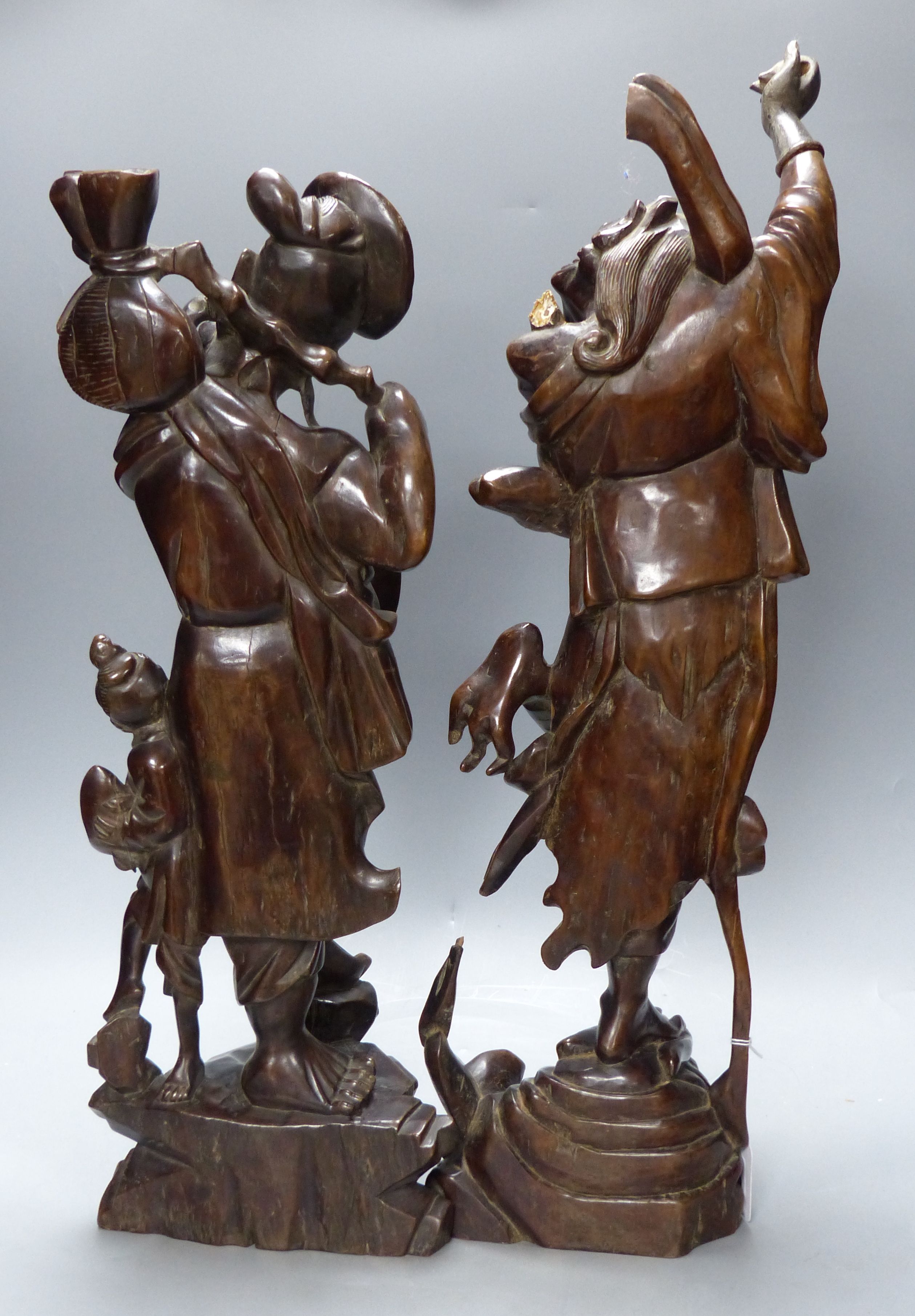 Two early 20th century Chinese hardwood figures of a demon and a fisherman, tallest 61cm